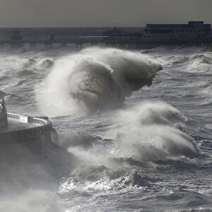 Waves break in front of the South Pier on Blackpool Promenade, northern Britain