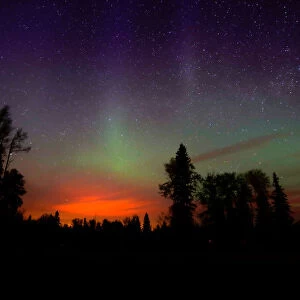The wildfires glow underneath The Northern Lights, also known as the Aurora Borealis