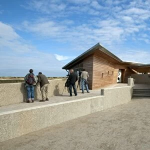 Birdwatchers standing beside new hides and information centre in coastal wetland reserve, Titchwell RSPB Reserve