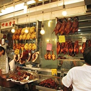 Man preparing meat and poultry at cafe, Kowloon, Hong Kong, China