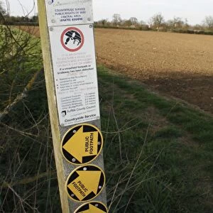 Public footpath sign with regulations for restoring disturbed crossfield footpaths, at edge of field in arable farmland, Bacton, Suffolk, England, april