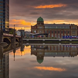 Redeveloped apartment building with copper dome, reflected in river at sunrise, Newport Technical Institute, River Usk