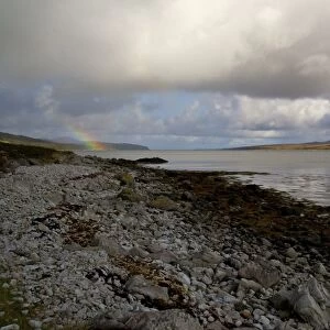 View of rainclouds and rainbow over coastal strait Islay Sound, Islay, Inner Hebrides, Scotland, september