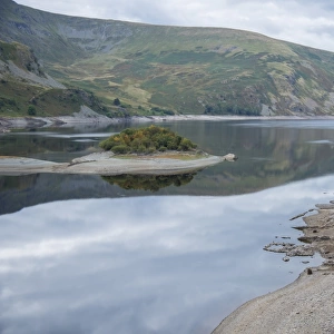 View of upland reservoir with low water level and remains of submerged village exposed after dry summer, Mardale Green