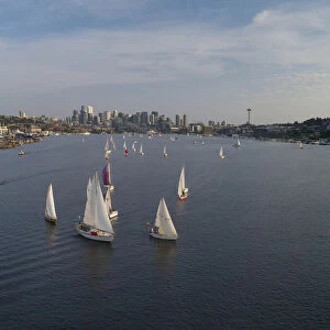 Aerial view of sailboats racing on Lake Union in the evening with the Seattle skyline in