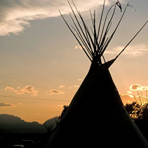Blackfeet tepees made from canvas stretched over tipi poles at sunset in Browning Montana