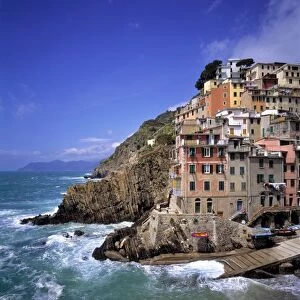 Europe, Italy, Riomaggiore. Riomaggiore is built on steep cliffs and the waves crash