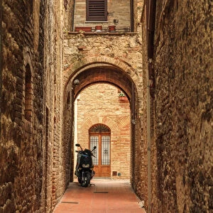 Italy, San Gimignano. Alleyway with motorbike