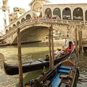 Italy; Venice. Tourists ride in gondolas on the Grand Canal near the Rialto Bridge