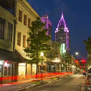 Mobile Alabama downtown traffic on Dauphin Street at twilight with Trustmark Skyscrapper