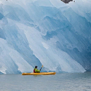 Port Nellie Juan, Prince William Sound, Alaska, a kayaker pauses to look at a magnificent