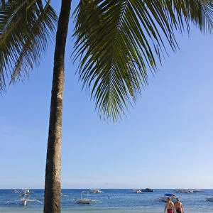 Tourists and palm tree on the beach, Bohol Island, Philippines
