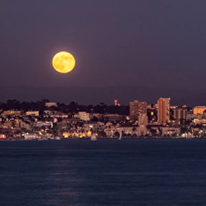 USA, California, San Diego, Panoramic view of full moon rising over city with sunset