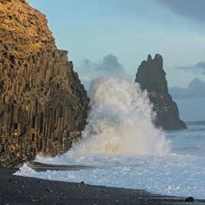 Waves from the North Atlantic Ocean crash into basalt columns at the Black Beach near Vik