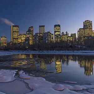 Winter city skyline reflects in the Bow River in Calgary, Alberta, Canada