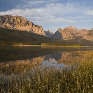 Wynn and Allen Mountains reflect into calm Lake Sherburne in Glacier National Park