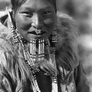 ALASKA: ESKIMO WOMAN. Eskimo woman from Nunivak Island wearing necklaces, earrings