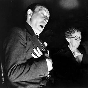 ENGLISH SEANCE. The medium Horace S. Hambling in a trance, insisting the spirit of Moon Trail, a dead Indian, is speaking through him; photographed in 1937