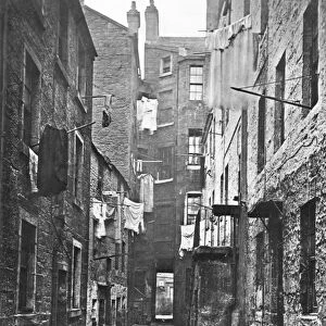 GLASGOW, SCOTLAND: SLUM. A close (alley) off High Street photographed in 1868 by