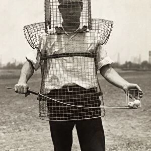 GOLF CADDY, c1920. Golf caddy Mozart Johnson wearing wire mesh protective device