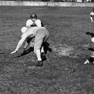 HIGH SCHOOL FOOTBALL, 1941. High school football players running plays in Cleveland, Ohio