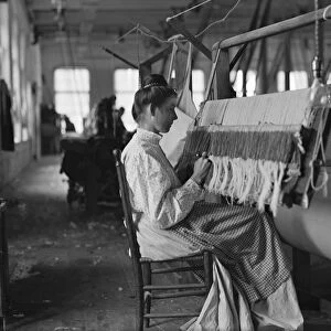 HINE: CHILD LABOR, 1908. A girl working at a beam warper in a textile mill, Cherryville