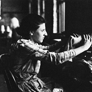HINE: KNITTING MILL. Young girl working on stockings at a knitting mill in America