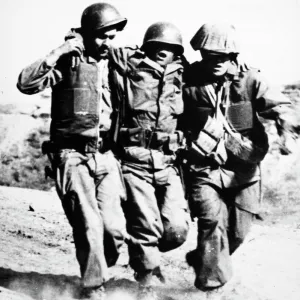 KOREAN WAR: PORK CHOP HILL. An American soldier, wounded at the Battle of Pork Chop Hill in 1953, receives assistance from two comrades