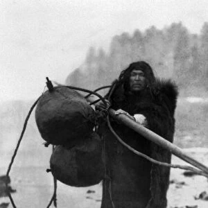 MAKAH WHALER, c1915. Wilson Parker, a Makah Native American whaler, carrying seal-skin floats