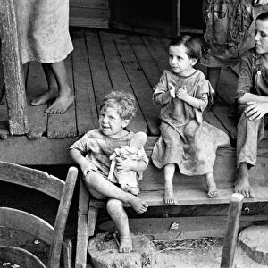MIGRANT CHILDREN, 1936. Impovished migrant children sitting on a porch in Hale County, Alabama