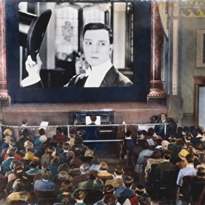 MOVIE THEATER, 1920s. Interior of an unidentified New York City motion picture theatre showing a film with Buster Keaton. Oil over a photograph, 1920s