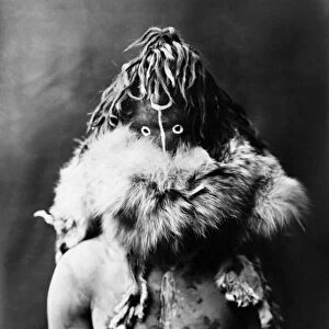 NAVAJO MASK, c1905. A Navajo man dressed up as the god Haschezhini, wearing a dark leather mask, a fur ruff, and white body paint on his torso. Photograph by Edward Curtis, c1905