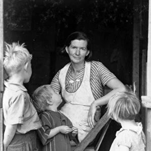OKLAHOMA SQUATTERS, 1935. A woman with her children at the entrance to a squatter s