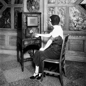 RADIO, c1920. A woman listening to the radio. Photograph, c1920