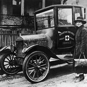 A Red Cross nurse with a new Model T Ford, in Bridgeton, Massachusetts. Photograph, 1916