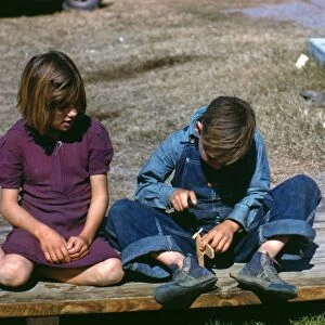 TEXAS: CHILDREN, 1942. A girl watching a boy build a model airplane at an FSA labor