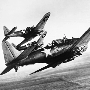 Three U. S. Navy Douglas SBD Dauntless dive bombers flying over the Pacific Ocean