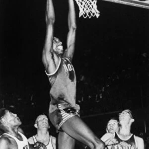 WILT CHAMBERLAIN (1936-1999). American basketball player. Chamberlain dunking the basketball while playing with the University of Kansas, c1956
