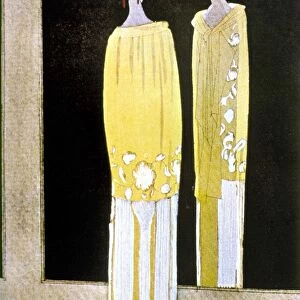 WOMENs FASHION, 1920s. A woman wearing a yellow and white Vionnet dress with floral design, looking at her reflection in a mirror. French fashion plate, circa 1920s