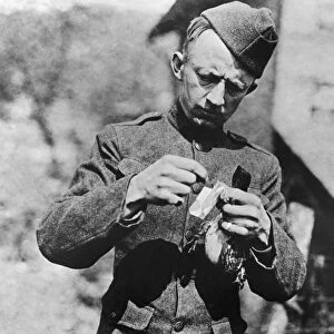 WORLD WAR I: HOMING PIGEON. A soldier removes a message from the leg of a homing