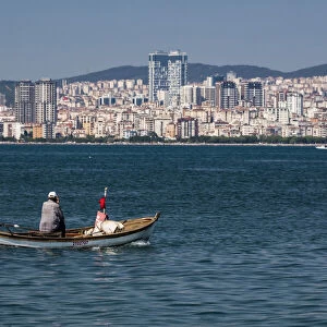 A man in a small boat off the island of Büyükada, one of the Princes` Islands near Istanbul, Turkey