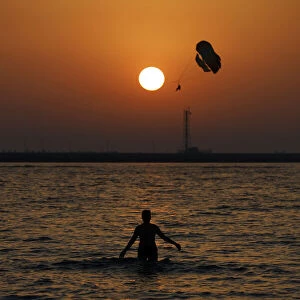 Al Hamra Beach on the Arabian Gulf at Ras Al Khaimah. Woman at beach at sunset. United Arab Emirates