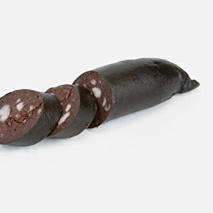 Black pudding with some slices cut away, close-up