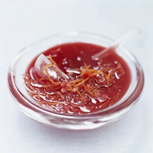 Cumberland sauce served in a glass bowl with small ladle, close up