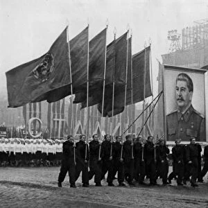 A demonstration / parade of the working people in red square in moscow on november 7, 1950, the sportsmen are carrying soviet flags and an image of stalin