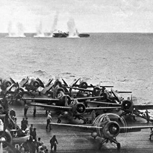 Japanese salvos drop next to the USS White Plains as the USS Kitkun Bay scrambles its fighters during the 2nd Battle of the Philippine Sea