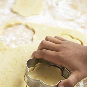 Making calendula cookies, childs hand using cookie cutter