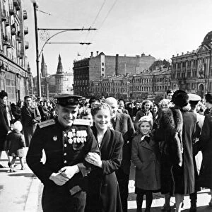 A red army soldier and his girlfriend on gorky street after the victory day celebrations in red square on may 9, 1945, the towers of the moscow kremlin can be seen in the background
