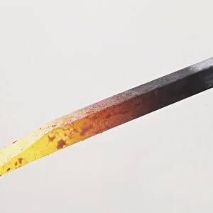 Red-hot metal rod reaching white heat, close up