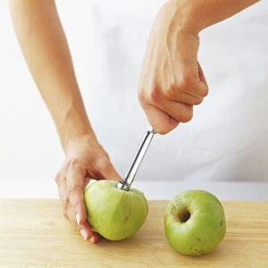 Using a coring tool to removed core from an apple